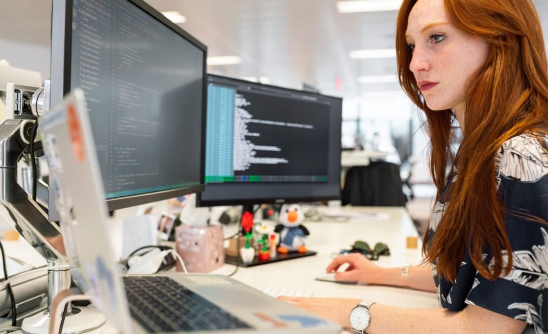 A developer at a desk with several screens
