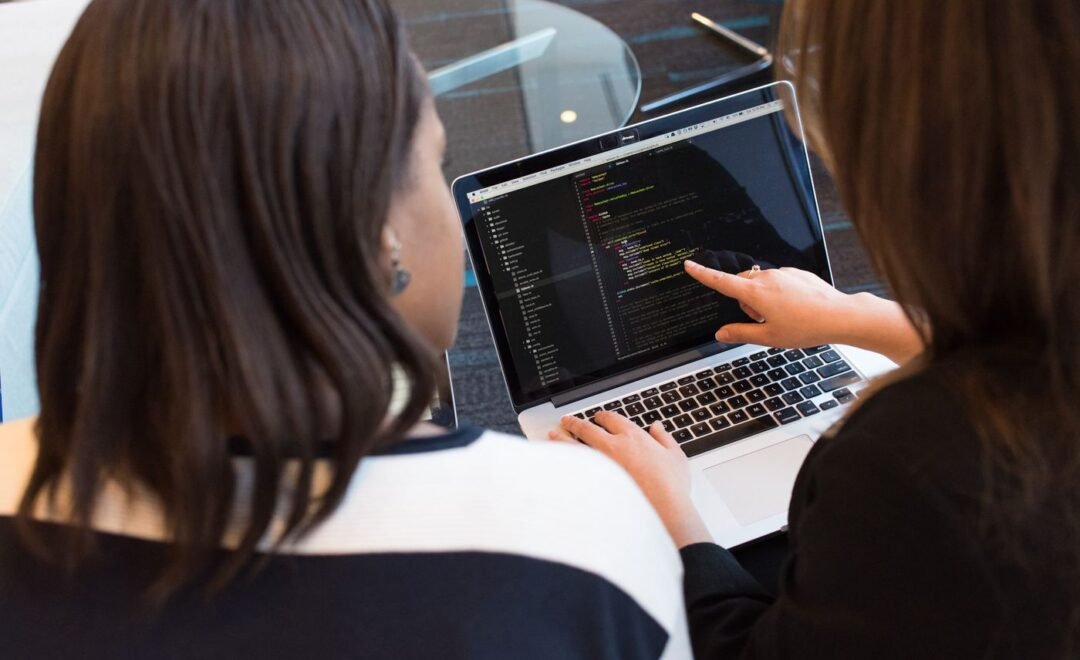 A developer writing code on a laptop