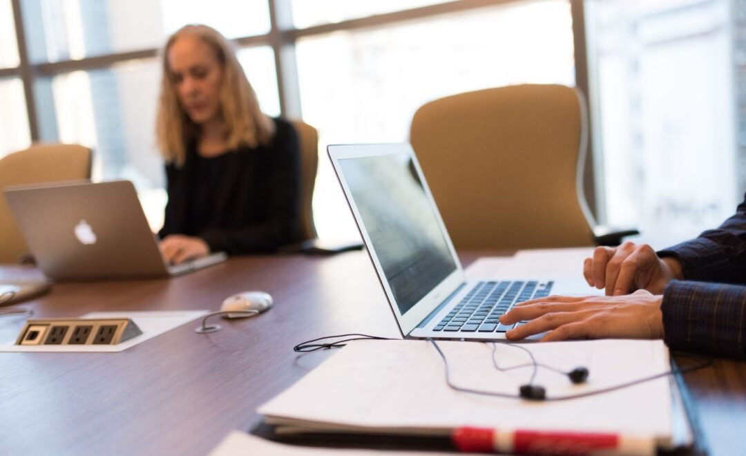 A team reviewing work on laptops in a meeting room