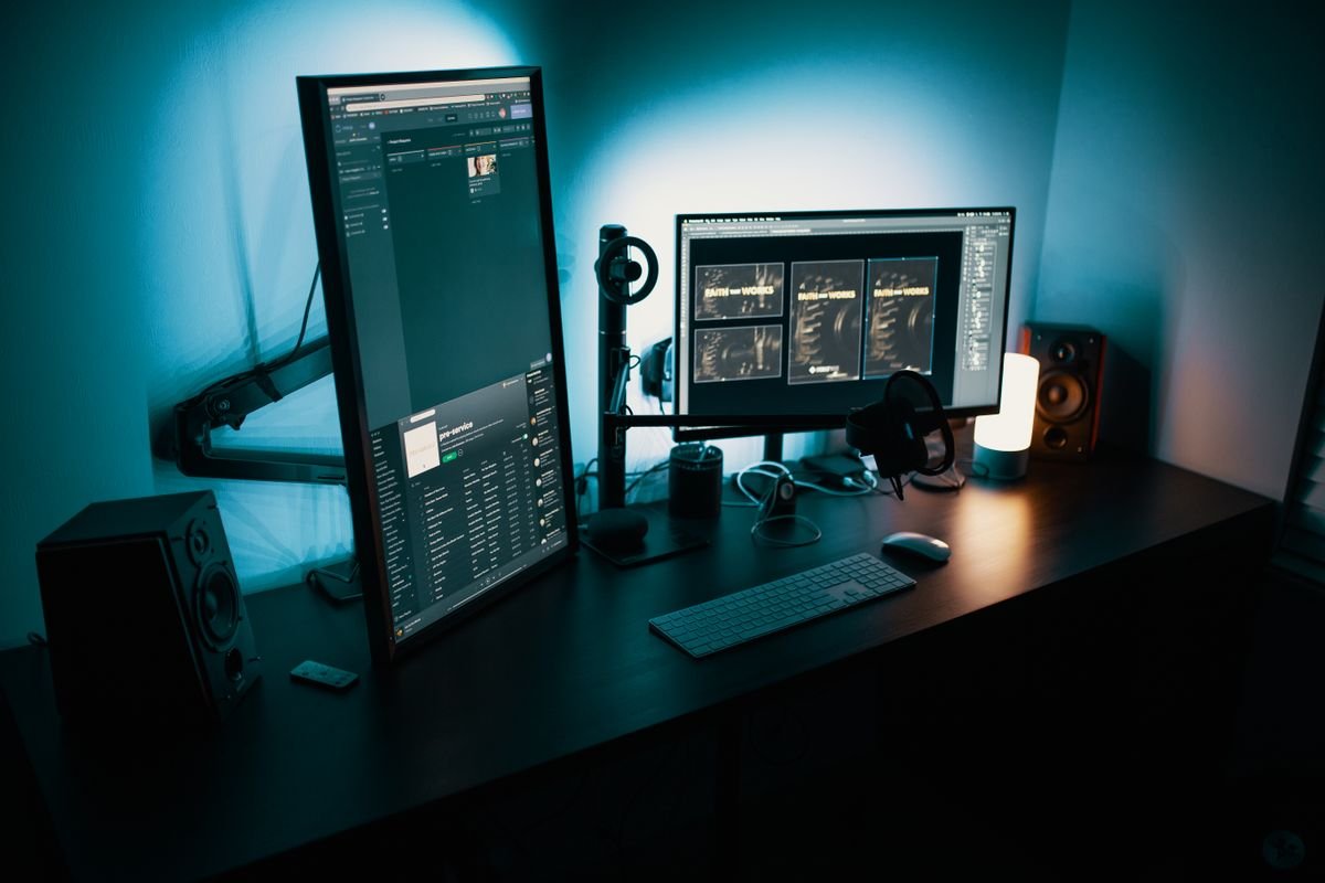 Desk setup with monitors lit in the evening