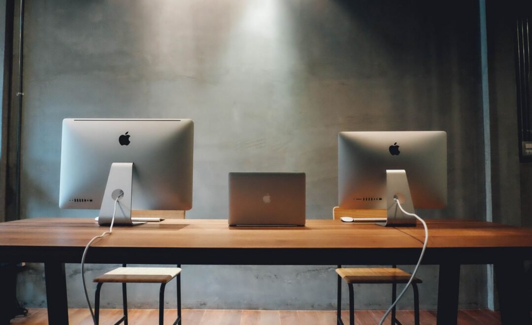 Two desktop computers on a shared workbench