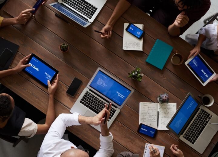 A team reviewing a redesign plan on laptops and tablets