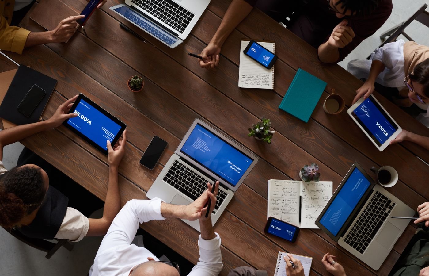 A team reviewing a redesign plan on laptops and tablets