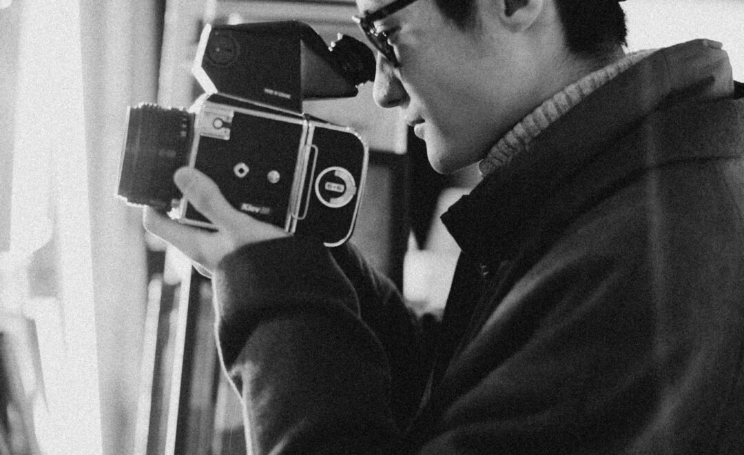 A photographer framing a shot with a camera