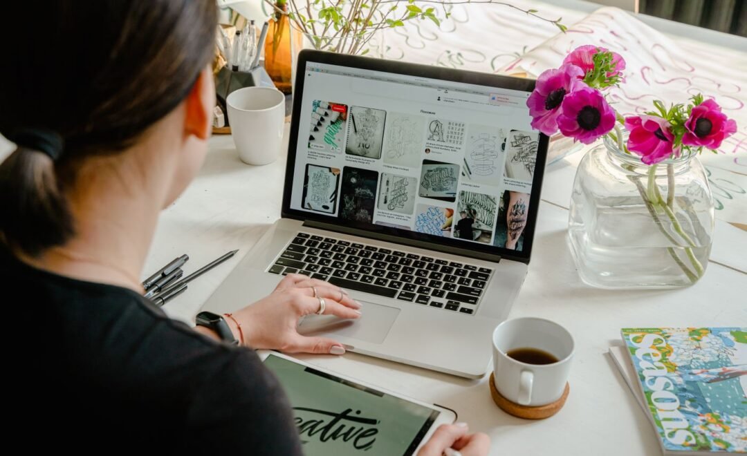 A designer working on brand layouts at a laptop