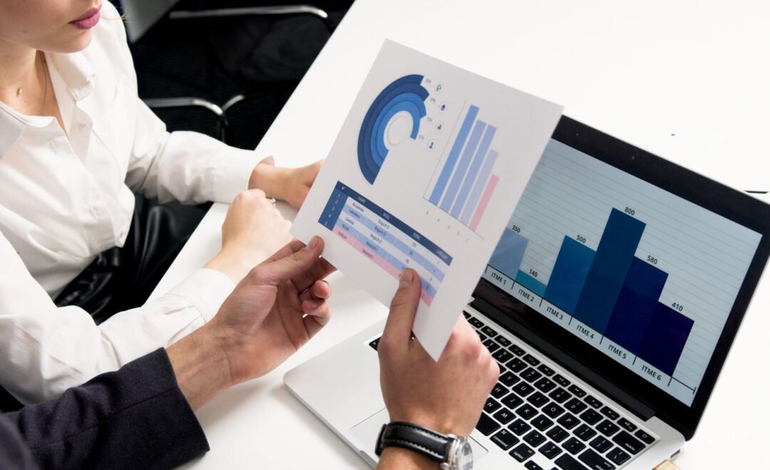 Two people reviewing analytics charts on a laptop