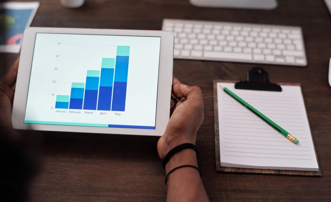 A bar chart on a monitor beside a notepad