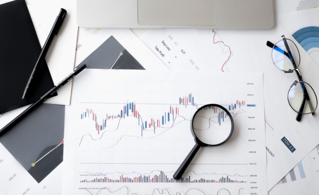 A magnifying glass over printed performance charts